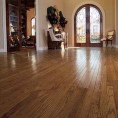 an empty living room with wood floors and arched glass doors