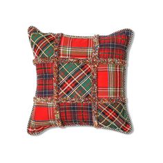 a red and green plaid pillow sitting on top of a white wall