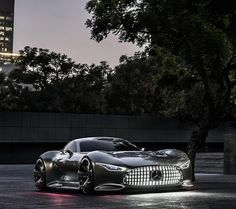 a mercedes sports car is shown in front of a cityscape at night with its lights on