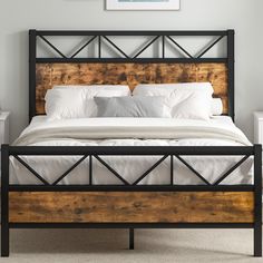 a bed with white linens and wooden headboard, in a room that has carpeted flooring