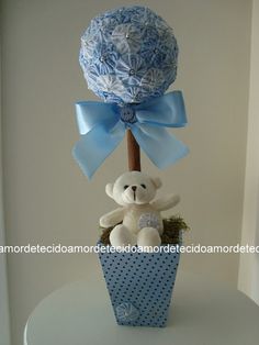 a teddy bear sitting on top of a box with a blue bow around it's neck