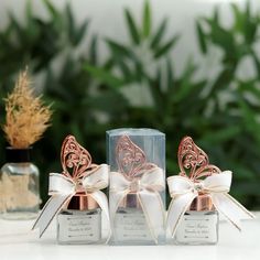 three small glass bottles with bows on them sitting next to each other and one is empty