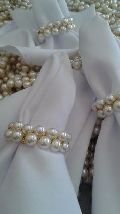 white satin with pearls on it and some other beads in the background, all tied together