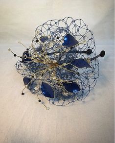 Delicate gold and blue fascinator perfect for the guest who wants something fairly understated. This design is a beautiful selection of glass effect leaves and flowers clustered together amongst a fine layer of veiling and set onto a fine comfort base tiara band. As with all our designs, this piece can be made exact to the image or in any colour combination to match in with your outfit. If a specific colour is required customers can message over an image of their outfit and accessories, or if ti Gold Fascinator, Blue Fascinator, Gold Hats, Wedding Headdress, Navy Hats, Alice Band, Wedding Hats, Color Swatches, Headdress