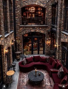 a living room filled with lots of furniture next to a fire place in a stone building