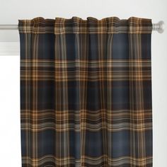 a plaid curtain hanging on the side of a window