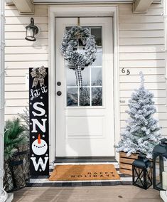 the front door is decorated for christmas with wreaths and snowman decorations on it