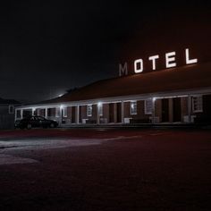 a motel lit up at night with the word motel on it's front and side