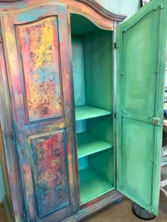 an old, painted armoire is open to reveal the inside of it's contents