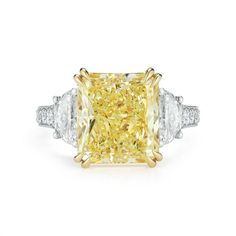 a fancy yellow diamond ring with three white diamonds