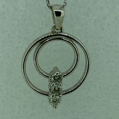 "14kt White Gold Lady's Diamond Double Circle Necklace consisting of 3 full cut round brilliant diamonds .33ct total weight SI1 clarity, G color all prong set in a double \"Circle of Life\" pendant. The FREE 16\" solid link curb chain has a lobster claw clasp. The total pendant circle measures 3/4\". This item would Retail for $1,790.00" Fine Jewelry White Gold Three Stone Diamond Necklace, White Gold Three Stone Diamond Necklace, Silver Diamond Three Stone Necklace, Silver Three Stone Diamond Necklace In Fine Jewelry Style, Three-stone Cubic Zirconia Diamond Necklace In White Gold, Silver Three Stone Diamond Necklace, White Gold Cubic Zirconia Three Stone Diamond Necklace, Formal Three Stone Round Diamond Necklace, Formal Three Stone White Gold Diamond Necklace