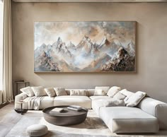 a living room with a large painting hanging on the wall and a white couch in front of it