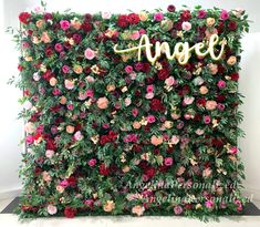 an artificial flower wall with the word angel spelled on it