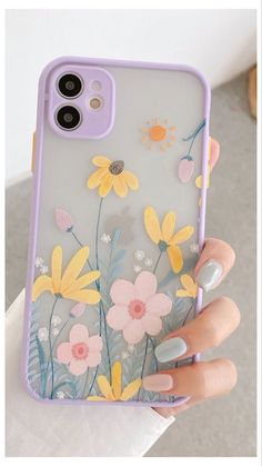 a woman's hand holding a phone case with flowers painted on the front and sides