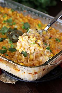 a spoon full of mexican corn casserole with tortilla chips