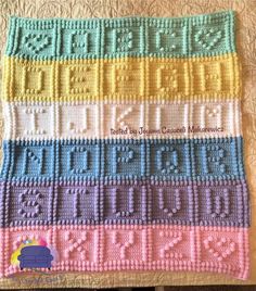 a crocheted blanket with numbers and letters in different colors on top of it