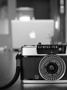 an old camera sitting on top of a wooden table