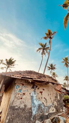 an old building with graffiti on it and palm trees in the background