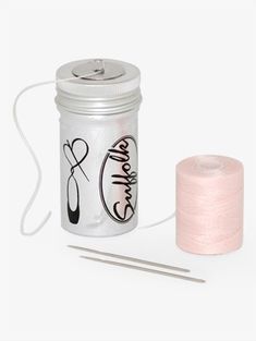 a pink thread and needle next to a glass jar