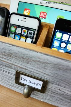 two cell phones in a wooden drawer with magnets on the bottom and an iphone sitting next to them