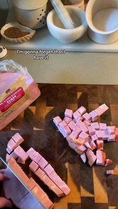 someone is chopping ham on a cutting board with a knife and other food items