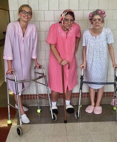 three women in pink dresses standing next to each other with crutches and canes