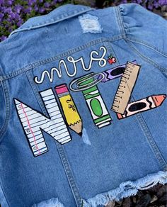 a jean jacket that has some writing and pencils on it, with the word denim written