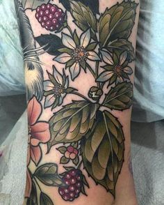 a woman's foot with flowers and leaves on it, in the middle of her leg