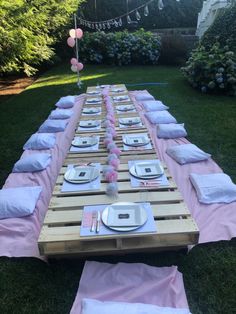 a long table set up with plates and napkins for a party or outdoor event