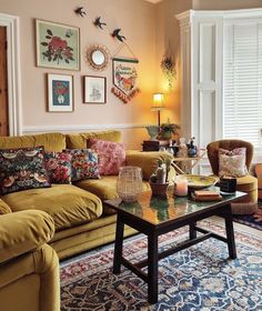 a living room filled with lots of furniture next to a wall covered in framed pictures