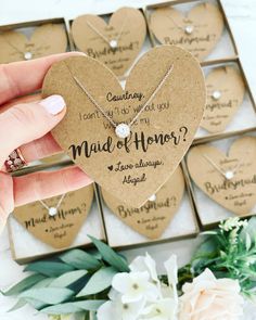 a person holding a heart shaped necklace in front of a box with other hearts on it