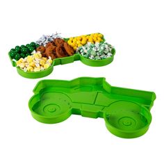 two plastic trays filled with candy and candies on top of each other, one in the shape of a car