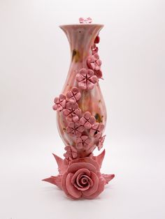 a pink vase sitting on top of a white table