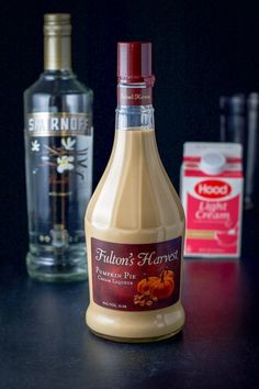 a bottle of liquor sitting on top of a table next to two bottles of alcohol