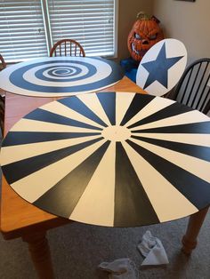 two large black and white striped umbrellas sitting on top of a dining room table