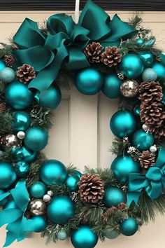 a christmas wreath with blue ornaments and pine cones