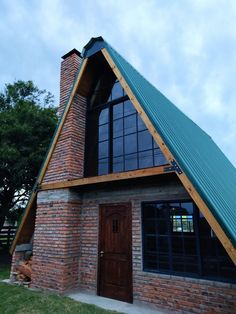 a small brick house with a green roof