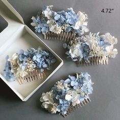 four hair combs with blue and white flowers on them sitting next to a box