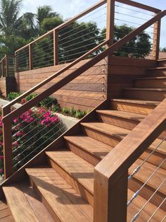 a wooden staircase with metal handrails and flowers