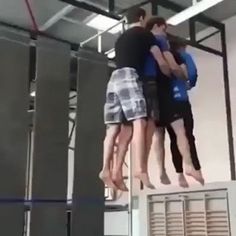 three people are hanging upside down in the air