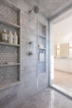 a bathroom with white marble walls and shelves