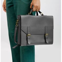 a person holding a gray briefcase in their left hand and green pants on the other