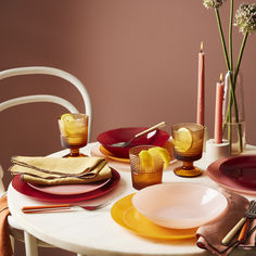 a table set with plates, napkins and candles