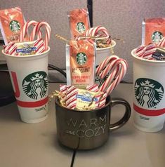 starbucks coffee cups with candy canes in them and wrapped in wrappers on the side