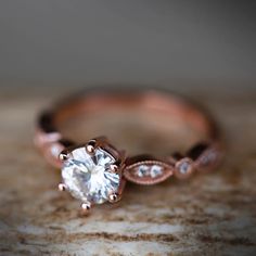 a rose gold engagement ring with a white diamond