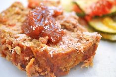 a close up of food on a plate with zucchini and meatloaf