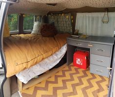 the inside of a van with a bed and desk