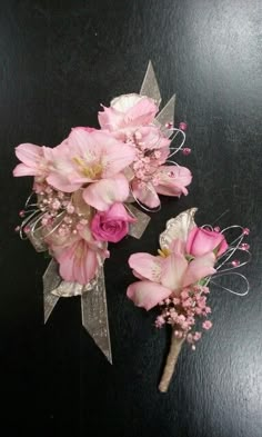 two bouquets of pink flowers sitting on top of a black table next to each other