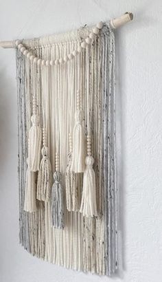 a white wall hanging with tassels and beads