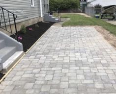 a brick walkway leading up to a house